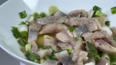 Dilimlenmiş turşulu ringa balığı, yeşil soğanlı, en iyi manzara.