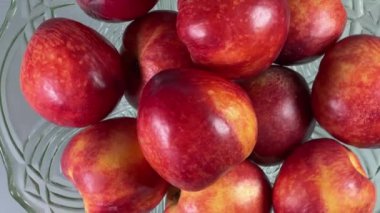 Gri arka planda eski meyve vazosundaki taze nektarinler