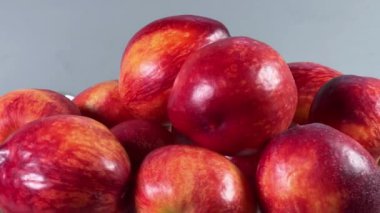 Gri arka planda eski meyve vazosundaki taze nektarinler