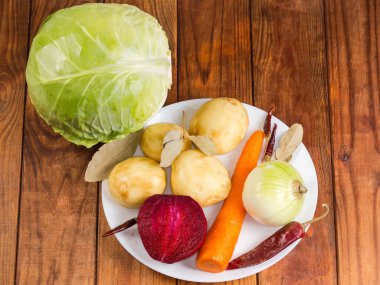 Kırmızı pancar çorbası hazırlamak için kırmızı pancar çorbası malzemesi olarak kabuğu soyulmuş taze sebzeler, beyaz lahana ve kurutulmuş baharatlar.