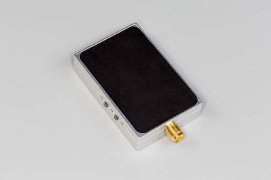 Gri arkaplanda sarı eşeksenli konnektörlü kapalı koruyucu metal kaplamalı minyatür yüksek frekanslı elektronik ünite.