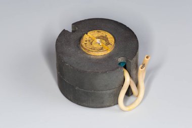 Gri bir yüzey üzerinde değişken mod güç kaynakları için tasarlanmış esrar tipi ferit çekirdekli eski kompakt yüksek frekanslı trafo.