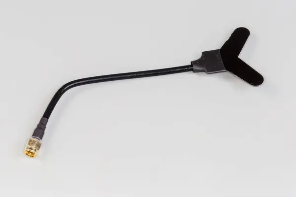 stock image Small-sized flat antenna of high-frequency mobile electronic unit with coaxial connector on the edge of coaxial cable on a gray background