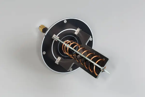 stock image Small-sized helical antenna of high-frequency mobile electronic unit with coaxial connector on the edge of coaxial cable on a gray background