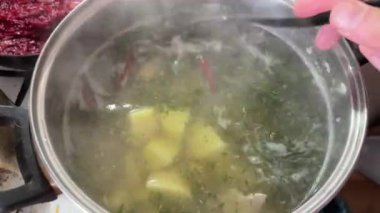 Paslanmaz çelik tencerede pişirilirken patatesli et suyu çorbası.