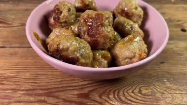 Kırsal bir masada pembe kasede köfteler hazır.