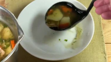 Tavuklu vermicelli çorbası dökülüyor tencereden kepçeyle tabağa