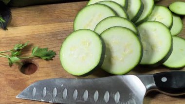 Yeşillikler arasında dilimlenmiş yeşil kabak.