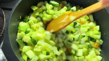 Kızartma tavasında haşlanmış kabak ve spatulayla karıştırılmış.