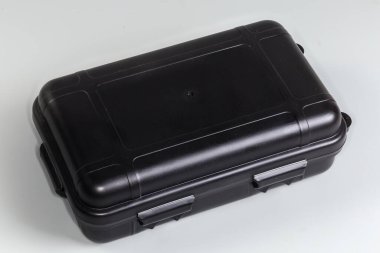 Aletlerin depolanması ve taşınması ve diğer amaçlar için gri bir arkaplan üzerinde kapalı küçük plastik taşınabilir araç kutusu
