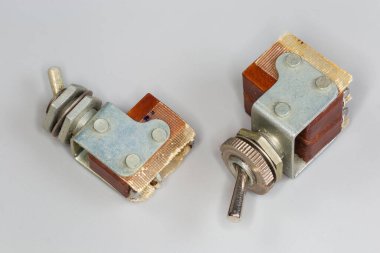 Gri arka planda bir ya da iki limitli şalter yapımında kullanılan iki eski elektrik düğmesi metal kaplama ve manivela ile