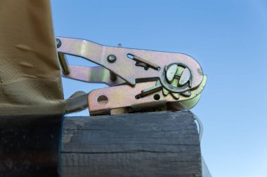 Çelik cırcırböceği mekanizması, ahşap kütüğe gerilme kemeri takmak için kullanılır ve açık gökyüzüne karşı kurulmuş bahçe yapısı için uygulanır.