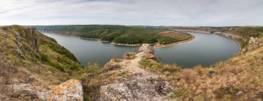 Dinyester Nehri 'nin kıvrımları kanyon benzeri vadiye sızıyor. Dik bir tepede kireçtaşı çıkıntıları, sonbahar bulutlu bir günde panoramik bir manzara.