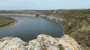 Sonbahar bulutlu bir günde kanyon benzeri bir vadide geniş bir nehir.