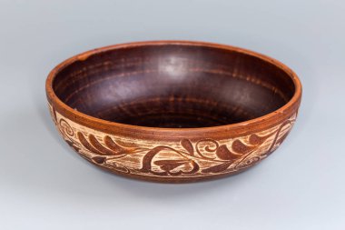 Gri arka planda geleneksel halk çiçekleriyle süslenmiş boş bir kase.