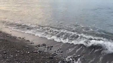 Bulutlu bir sabahta deniz kıyısında gökyüzüne karşı çakıl taşı plajı