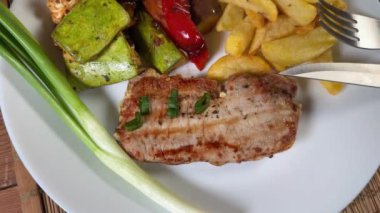 Kızarmış kemiksiz domuz pirzolası, fırında sebze ve ton balığı salatası.