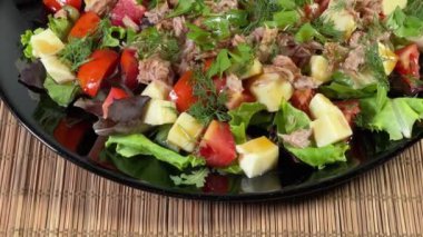 Konserve ton balığı, peynir, siyah tabakta taze sebze.