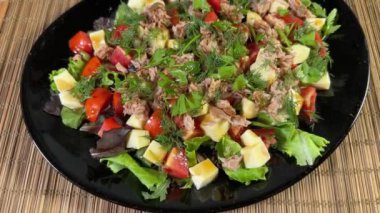 Konserve ton balığı, peynir, siyah tabakta taze sebze.