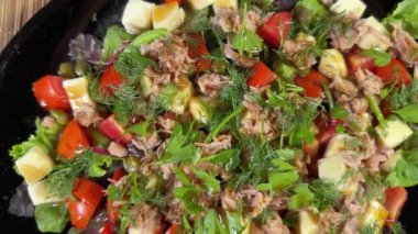 Konserve ton balığı, peynir, siyah tabakta taze sebze.