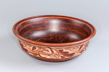 Gri arka planda geleneksel halk çiçekleri ile süslenmiş boş bir kase, seçici odak noktasında ön plan.