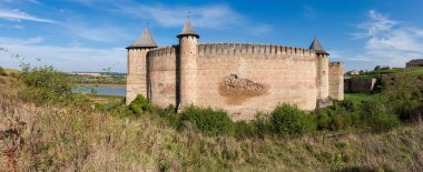 Khotyn fortress of the 14th century at autumn sunny day, Ukraine. Panoramic view of the west fortress defensive wall with towers clipart