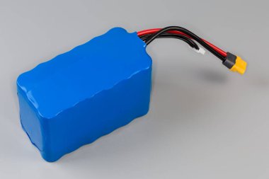 Güç ve kontrol kablolarına sahip şarj edilebilir batarya paketi gri arka planda UAV ve diğer mobil cihazlar için mavi plastik kaplama