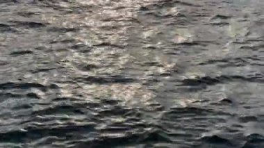 Su pürüzlü ve arka ışıklandırmalı deniz yüzeyinin bir parçası.
