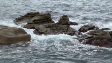 Deniz dalgaları kıyıya yakın kayalar arasında