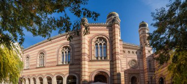 Upper part of main facade of the Dohany Street Synagogue, or Great Synagogue built in 19th-century with two towers with domes at autumn sunny morning, Budapest, Hungary, panoramic view clipart