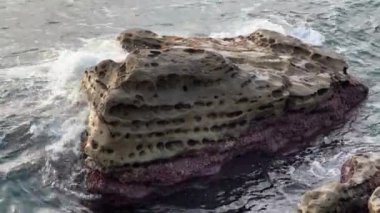 Kıyıya yakın küçük kayaların etrafındaki deniz dalgaları