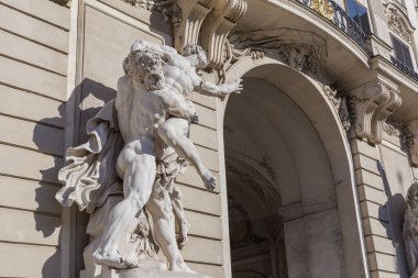 Herkül heykeli, güneşli bir günde Avusturya, Viyana 'da Hofburg' un St. Michael Kanadı İmparatorluk Başbakanlık Heykeli 'nin güneybatı cephesinde dev Antaeus' u yendi.