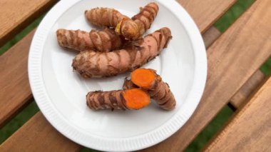 Tahta masadaki tabakta taze zerdeçal.