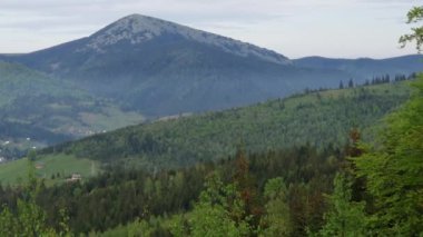 Karpat Dağları 'ndaki vadideki dağ köyü bulutlu bir akşamda