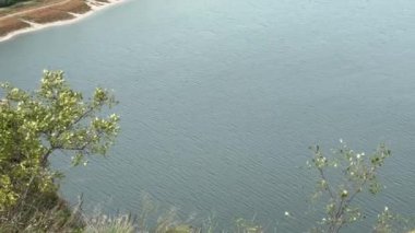 Önünde kaya çıkıntıları olan kanyon benzeri vadide bir nehir.