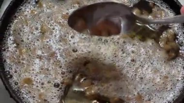 Kızartma tavasında ördek yağı var, kaşıkla karıştırıyor.