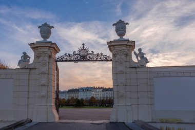 Yukarı Belvedere 'de sonbaharda gün batımında parçalı bulutlu gökyüzüne karşı açık yan kapı, Viyana, Avusturya, dışarıdan manzara