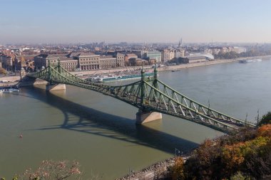Budapeşte 'nin Tuna Nehri üzerinde 19. yüzyılın perçinlenmiş demir örgülü Özgürlük Köprüsü. Sonbahar güneşli bir günde Gellert Tepesi 'nden görüntü