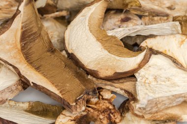 Tabak üzerine Boletus edulis 'in kurumuş dilimleri ve sapları, seçici odak noktasında yakın plan.