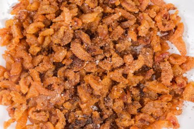 Ördek yağı ve deri dilimlerinden elde edilen bir yığın çıtırtı, uzun erime sürecinden sonra tuz ve karabiber ile tatlandırılmış, yakın çekim.