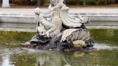 Sonbahar parkındaki havzada taş heykeller olan çeşme.