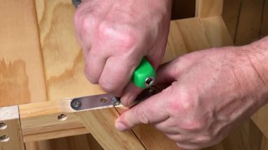 Mobilya vidalarının vidalanması menteşe manuel tornavidayla monte ediliyor