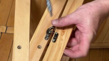 Mobilya kancası manuel tornavida kullanarak vidalarla monte ediliyor