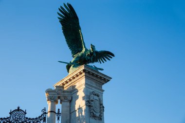 Mitolojik Turul kuşunun bronz heykeli Budapeşte 'deki Kraliyet Kalesi' nin kuzeydoğu köşesine oyulmuş taş bir heykel üzerine kurulmuş, gün batımında açık gökyüzüne karşı alttaki manzara