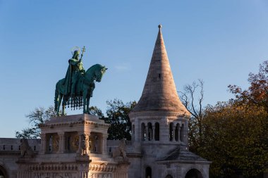 Macaristan Kralı ve kurucusu Aziz Stephen 'ın heykeli, güneş batarken Budapeşte' deki Balıkçı Kalesi 'nin kulesine karşı oyulmuş bir taş heykel üzerine bronz binicilik heykeli şeklinde.