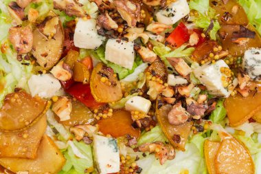 Doğranmış mavi peynirli salata, karamelli armut dilimleri, kavrulmuş ceviz, yapraklı marul ve diğer taze sebzeler.