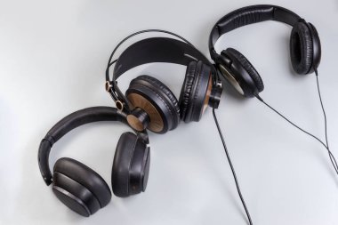 Modern iki çift farklı kablo ve bir kablosuz yüksek kaliteli kulaklık gri arka planda.