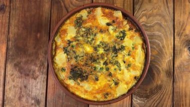 Erimiş peynirli güveç kasede, üst tarafta.