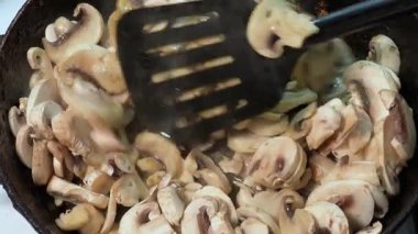 Kızartma sırasında kızartılmış tavada kızartılmış düğme mantarları.