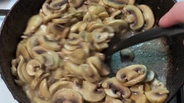 Kızartma sırasında kızartılmış tavada kızartılmış düğme mantarları.